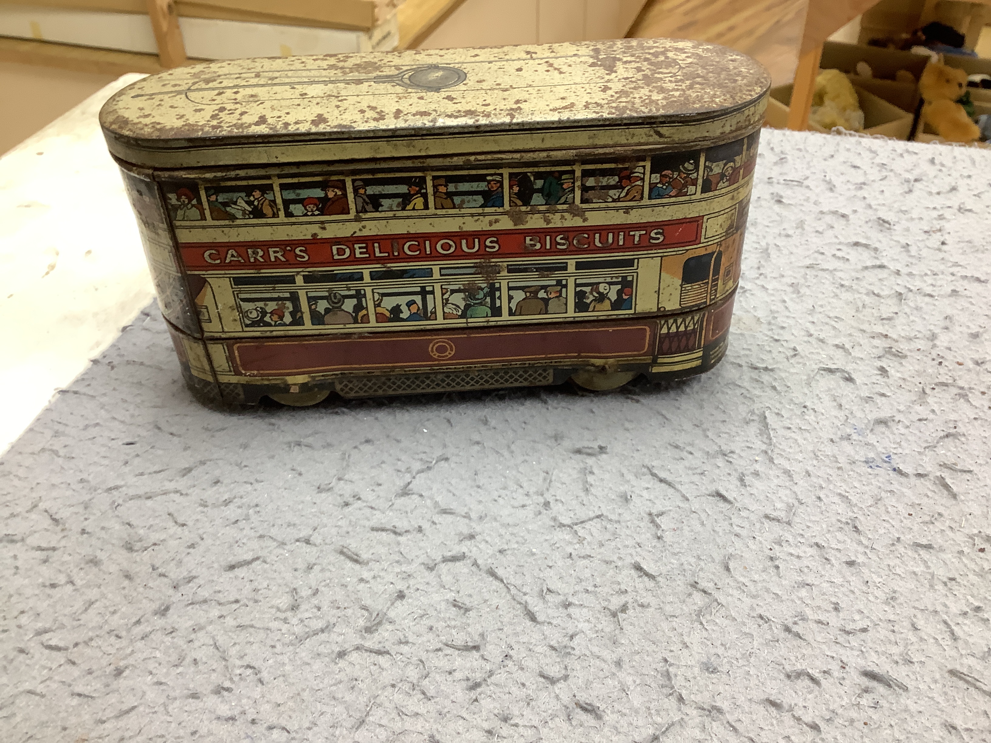 Three tinplate/cast iron toys; a Jaeger cast iron concrete mixer, a Carr’s tinplate biscuit tin in the form of a tram, and a clockwork teddy bear on a tricycle, tram 22cm long